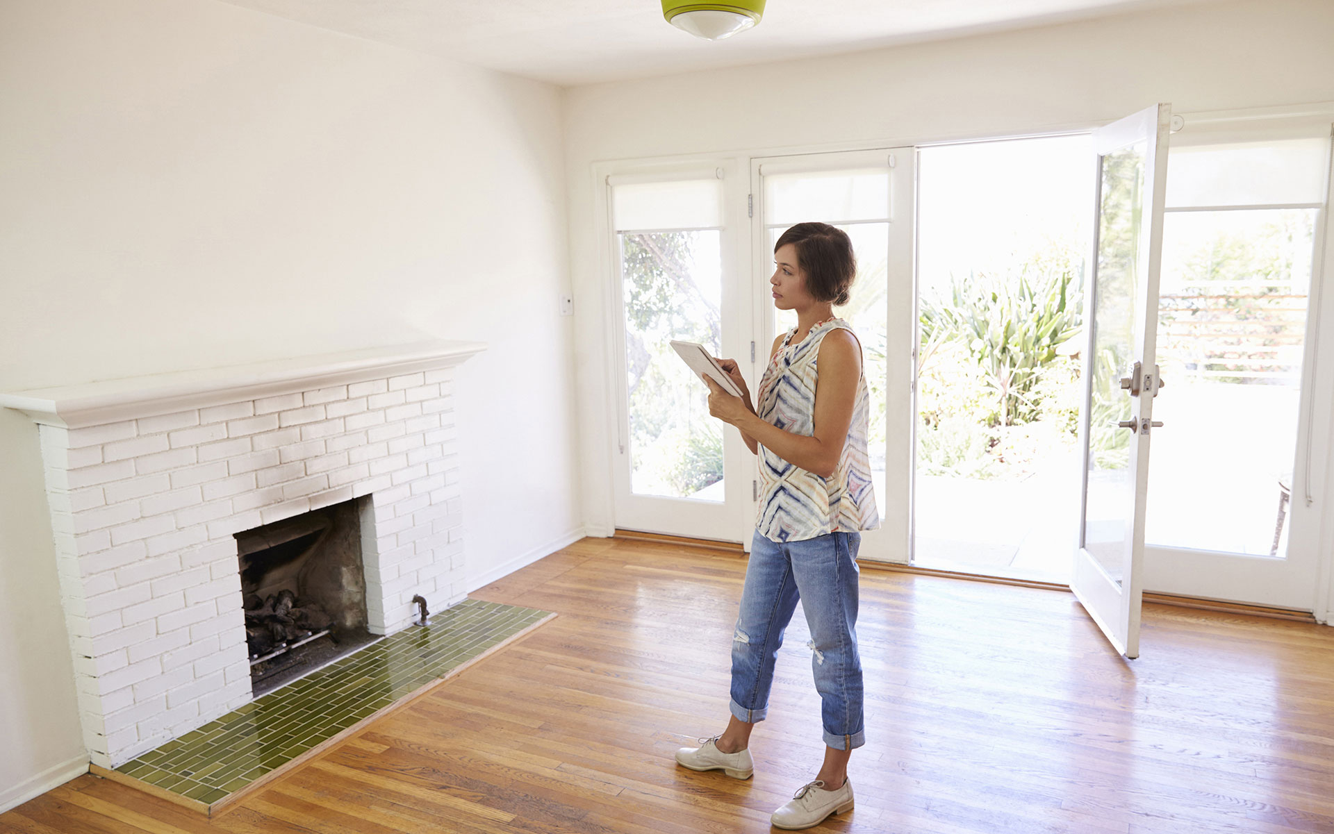 A woman holding a clipboard in an empty house